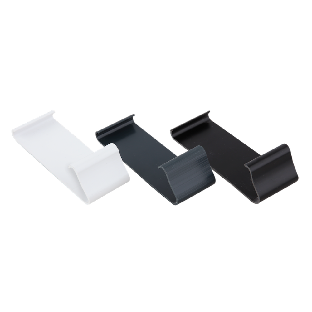 A white, an antrachite grey, and a black edge trim clip lying face up.