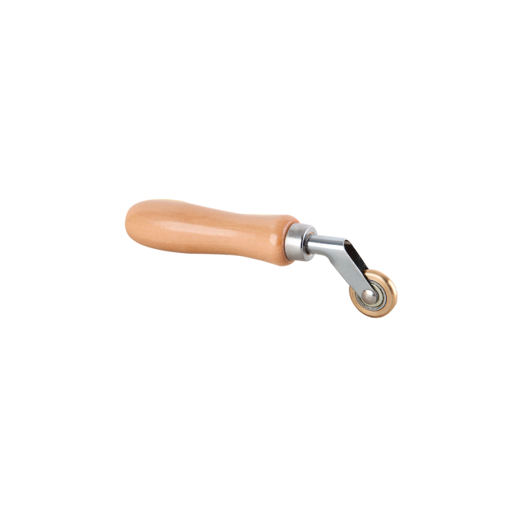 A wooden-handled tool featuring a brass-coloured wheel at one end.