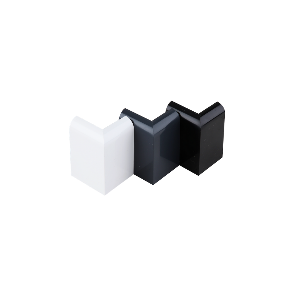 Three gutter trim external corner pieces standing upright, first the white, then the anthracite grey, then the black. 