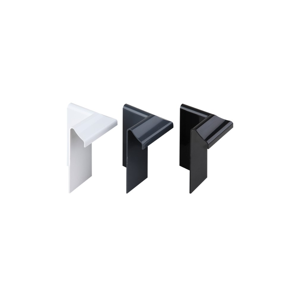 Three edge trim internal corner pieces standing upright, first the white, then the anthracite grey, then the black. 